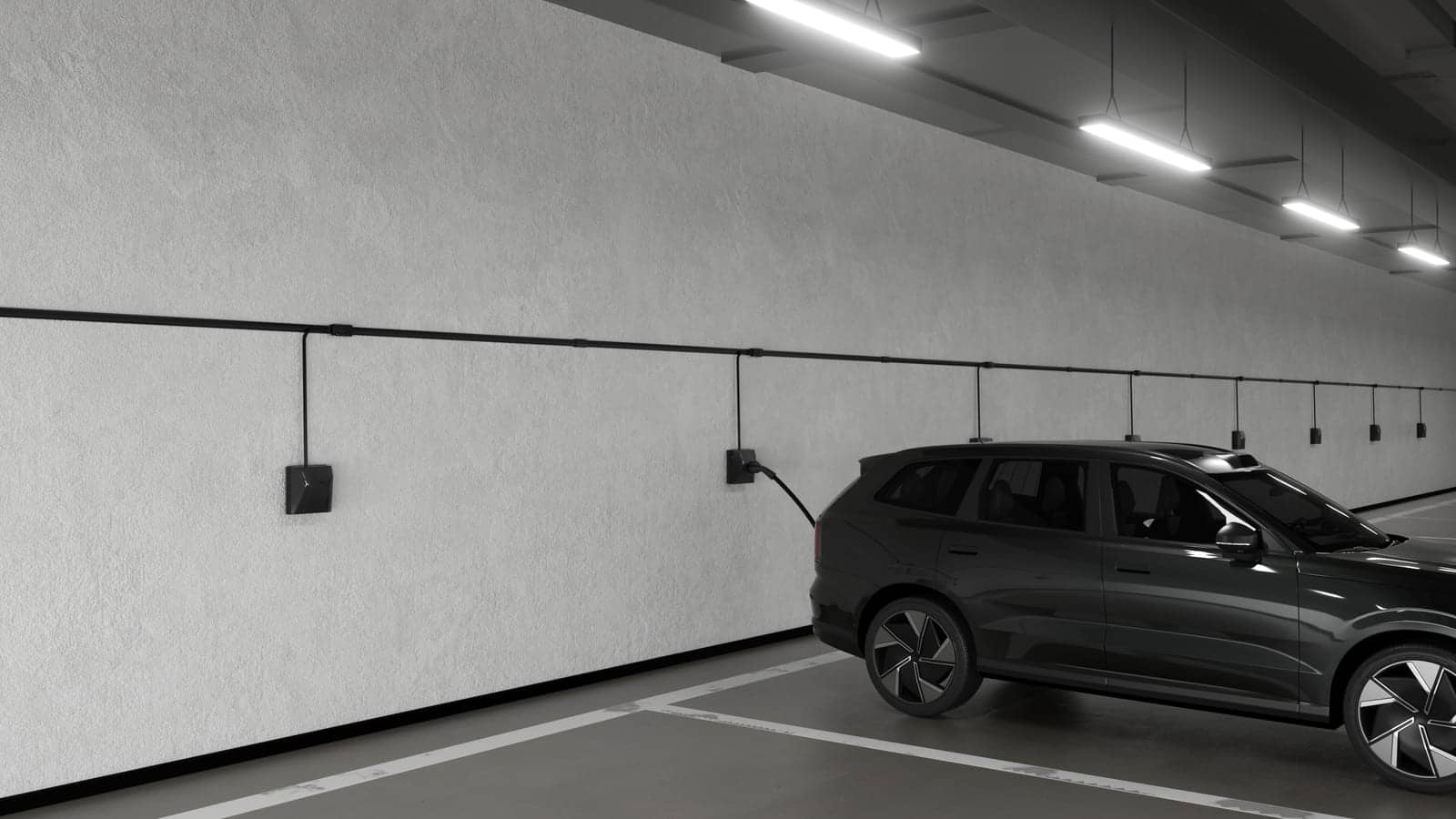 Rij laadpunten aan de wand van een ondergrondse parkeergarage, met een wagen die laadt