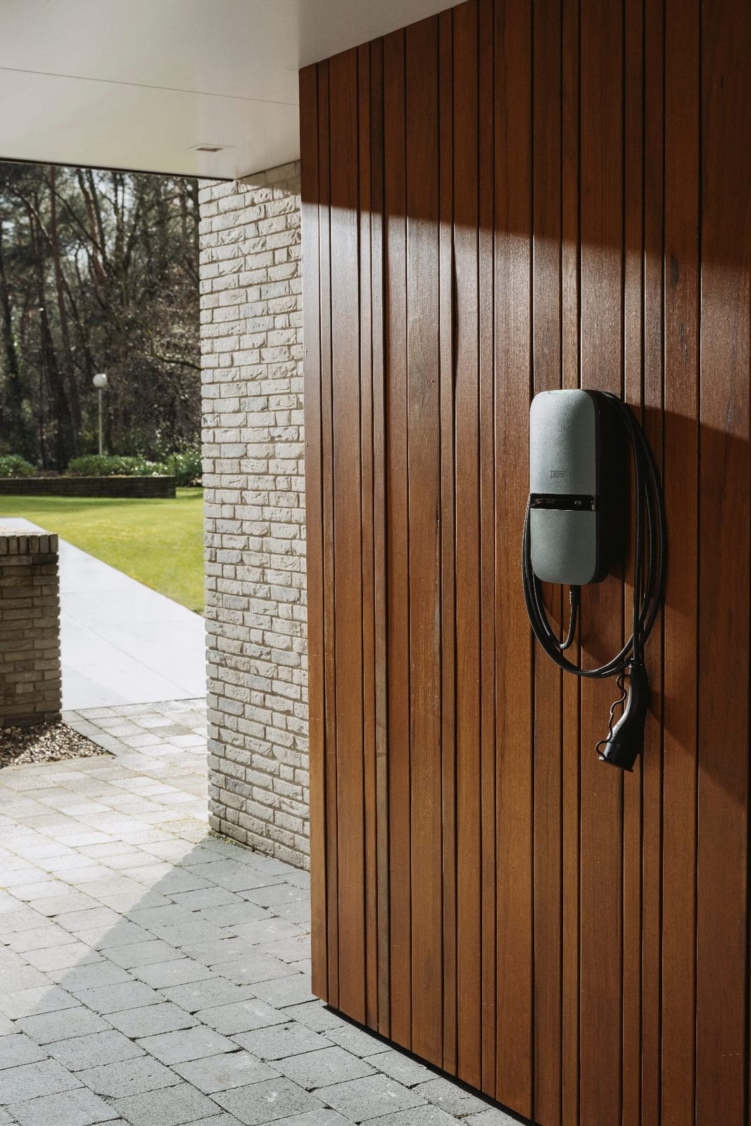 Peblar Home laadstation aan een woning met houten gevel